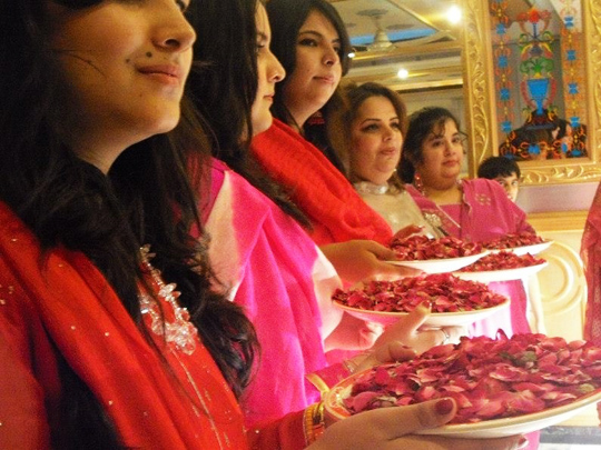 Girls waiting for the groom and his guests to shower them with rose petals